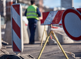 eine durch Baustellenbarken und Durchfahrtverbotssymbole gekennzeichnete Straßensperrung