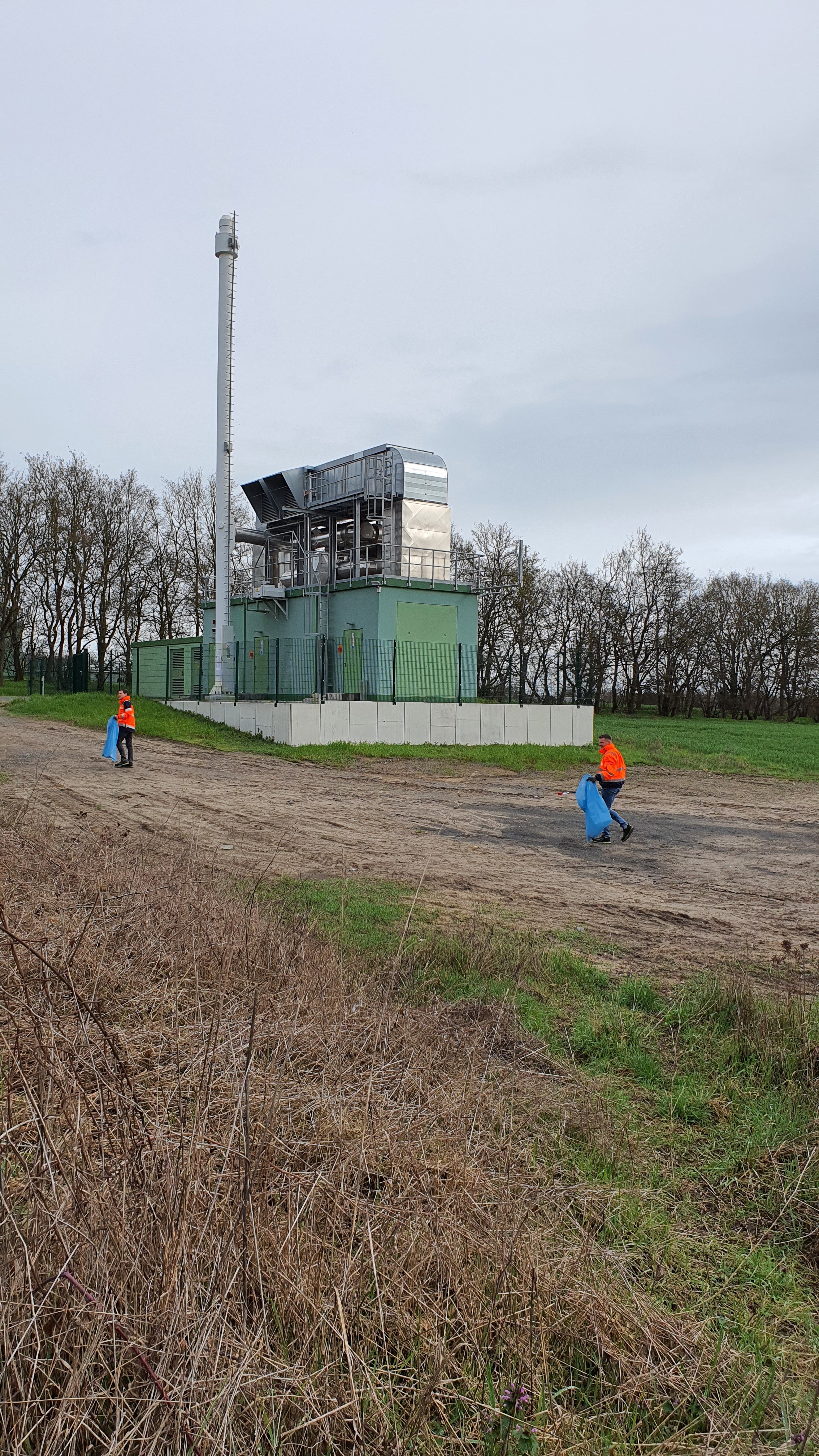 zwei Mitarbeiter der Stadtwerke Stendal, die im Rahmen der Frühjahrsputzaktion 2023 Müll am Kraftwerk sammeln